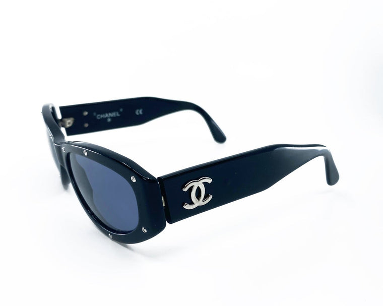 Fruit Vintage Chanel 1990s studded logo sunglasses. They feature silver screw shaped studs to the front of the frame and Chanel CC logo monograms to each side.
