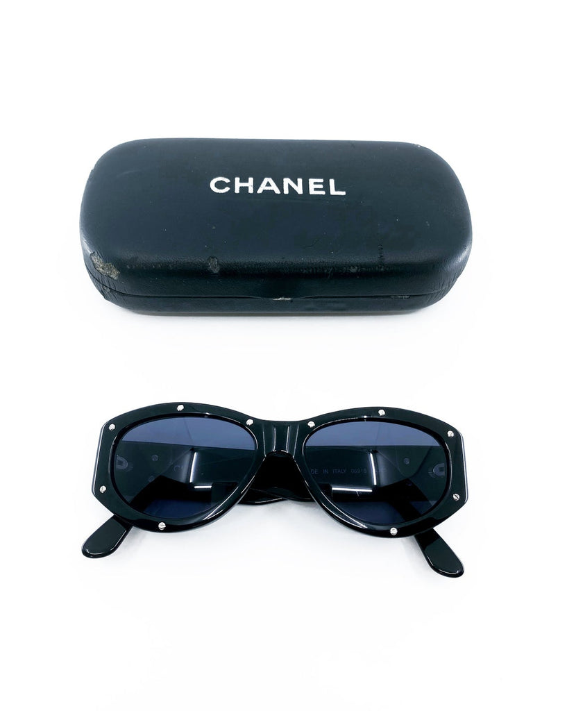 Fruit Vintage Chanel 1990s studded logo sunglasses. They feature silver screw shaped studs to the front of the frame and Chanel CC logo monograms to each side.