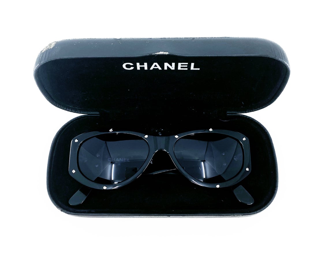 Fruit Vintage Chanel 1990s studded logo sunglasses. They feature silver screw shaped studs to the front of the frame and Chanel CC logo monograms to each side.