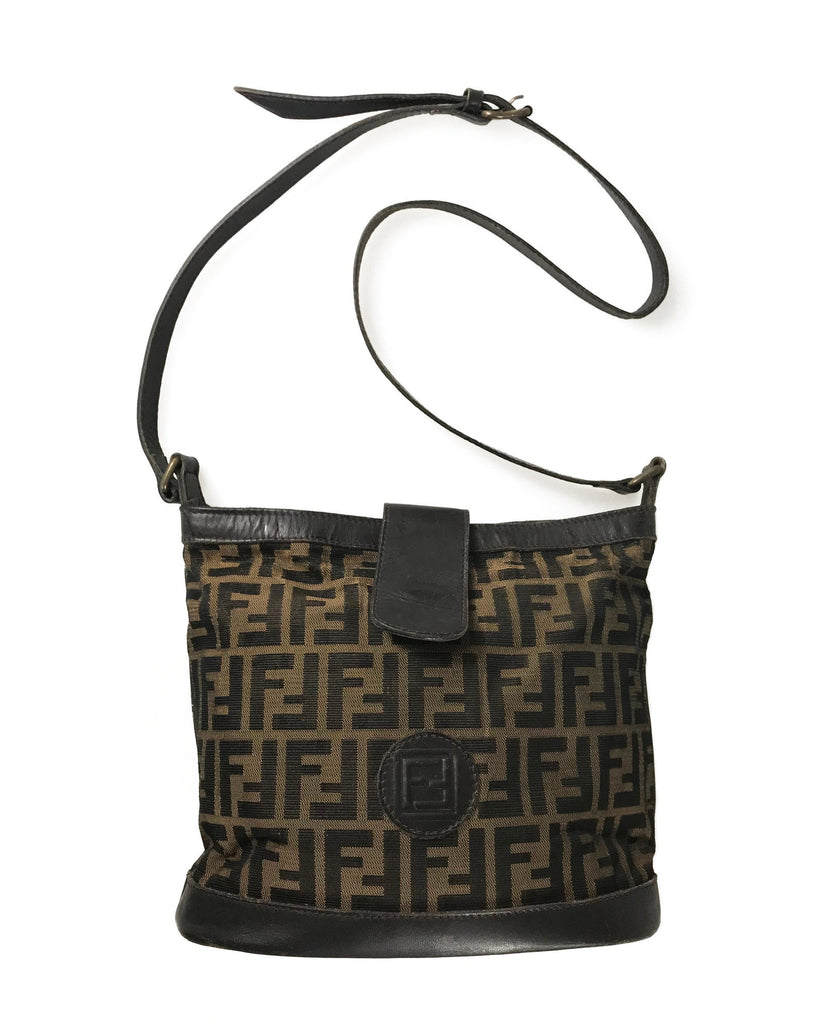 FRUIT Vintage Fendi Zucca cross body bucket bag dating to the 1980s. It features the classic Fendi Zucca monogram canvas, front embossed logo, top push button closure and long adjustable cross body strap..