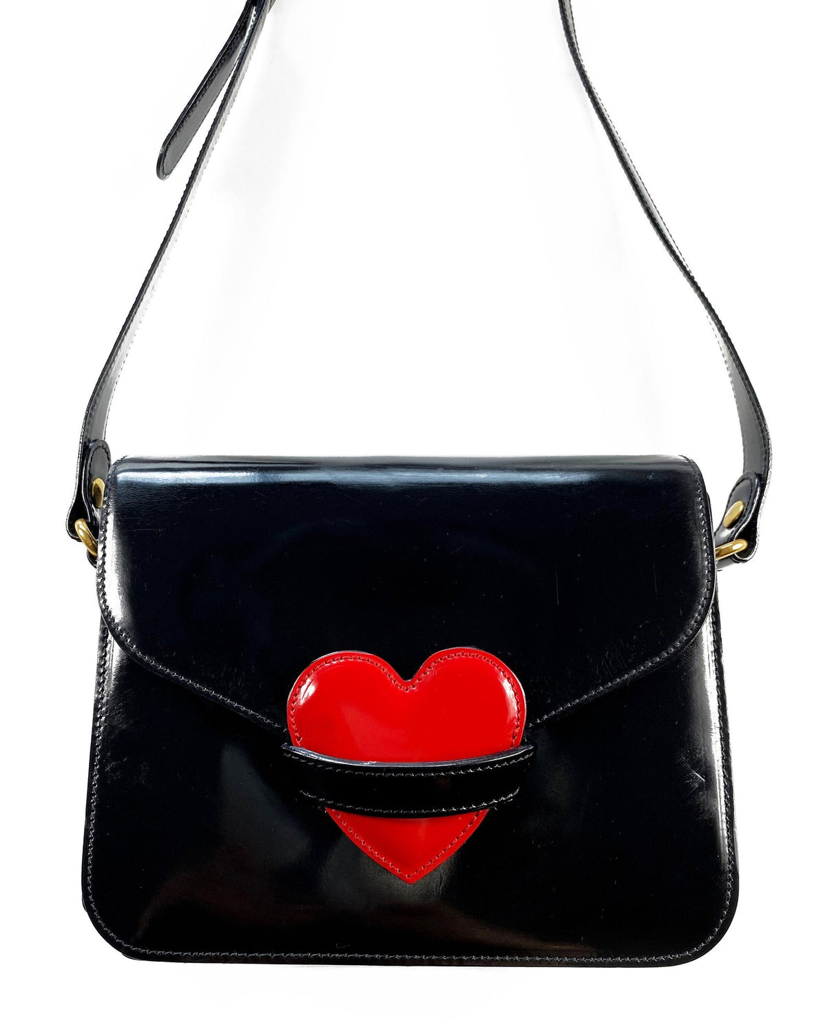 FRUIT Vintage rare Moschino heart cross body handbag in a classic satchel shape. Features an internal zipper pocket, Moschino logo lining, magnetic button front closure, Moschino Redwall authenticity stamp and logo plaque at side.