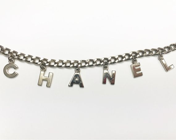 Fruit Vintage Chanel logo monogram letter chain belt in classic silver. Features a hook closure and logo drop Chanel CC charm.