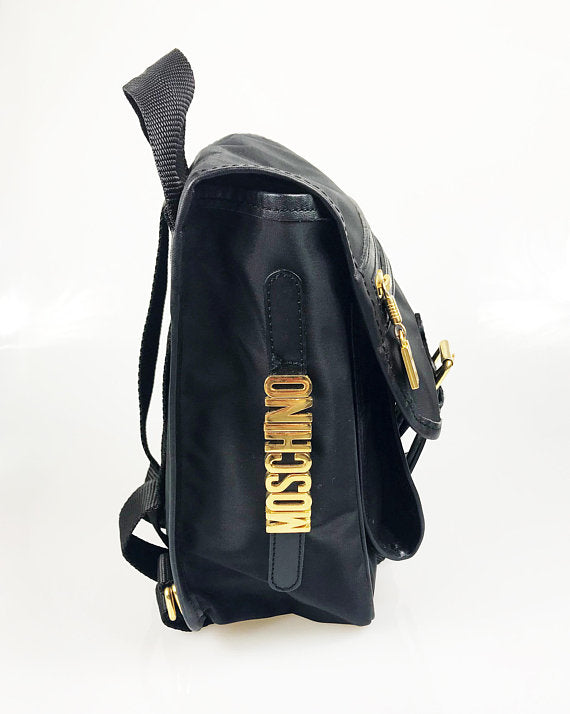 FRUIT Vintage Moschino mini backpack bag with the iconic Moschino gold lettering logo to one side, classic Moschino M logo zipper pull, and Redwall logo lining.