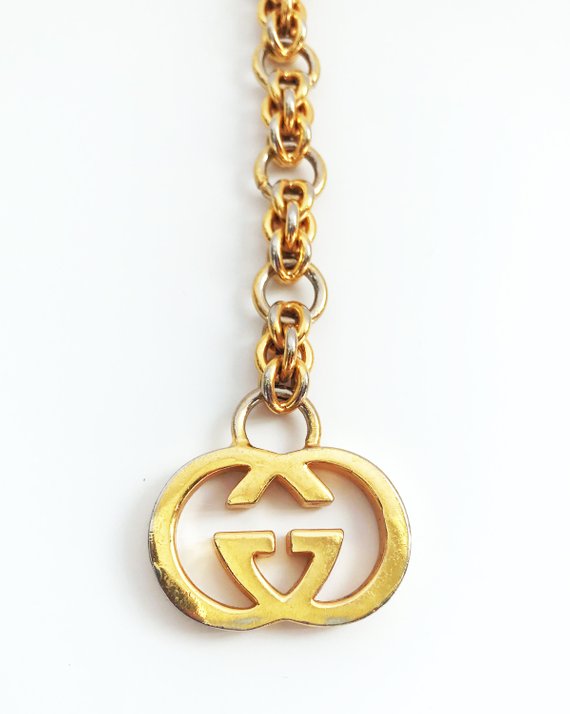 Fruit Vintage 1980s Gucci logo chain belt in classic gold. Features a lobster clip closure and significant logo drop Gucci GG charm.