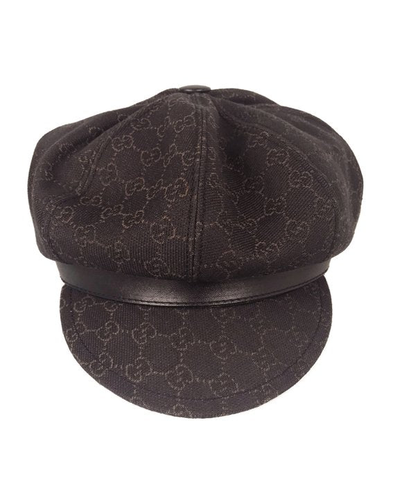 A passerby wears a black fabric Gucci Monogram bob hat with a