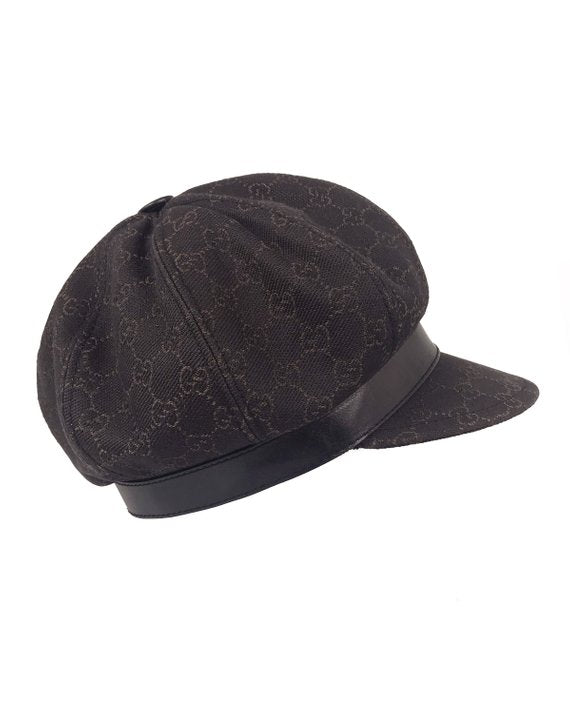 A passerby wears a black fabric Gucci Monogram bob hat with a