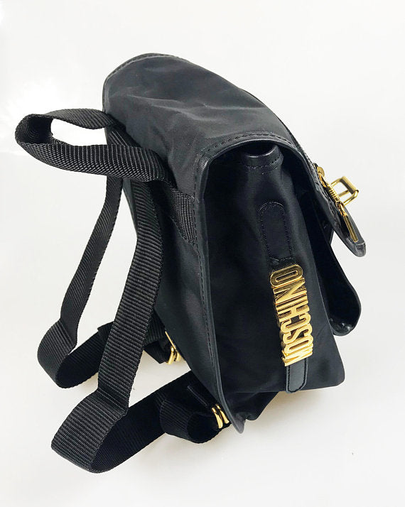 FRUIT Vintage Moschino mini backpack bag with the iconic Moschino gold lettering logo to one side, classic Moschino M logo zipper pull, and Redwall logo lining.