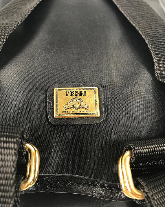 FRUIT Vintage Moschino mini backpack bag with the iconic Moschino gold lettering logo to one side, classic Moschino M logo zipper pull, and Redwall logo lining.