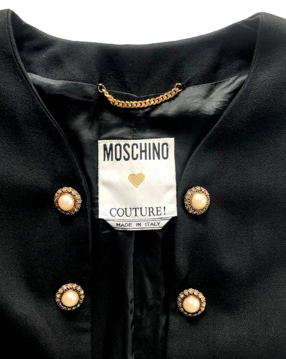 FRUIT Vintage rare Moschino Black Peace and Pearls jacket dating to 1989 in Mint condition. Hand sewn with a large pearl peace sign and the iconic Moschino monogram slogan text embroidered in gold.