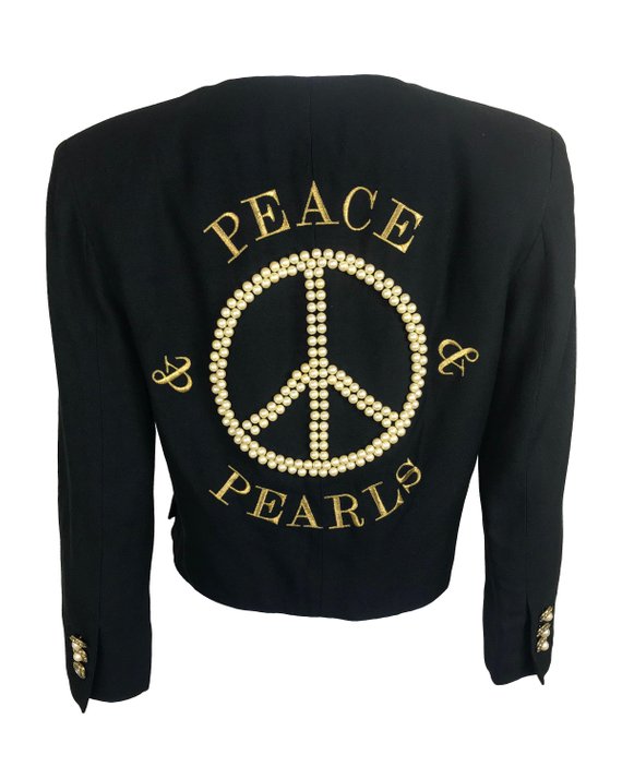 FRUIT Vintage rare Moschino Black Peace and Pearls jacket dating to 1989 in Mint condition. Hand sewn with a large pearl peace sign and the iconic Moschino monogram slogan text embroidered in gold.