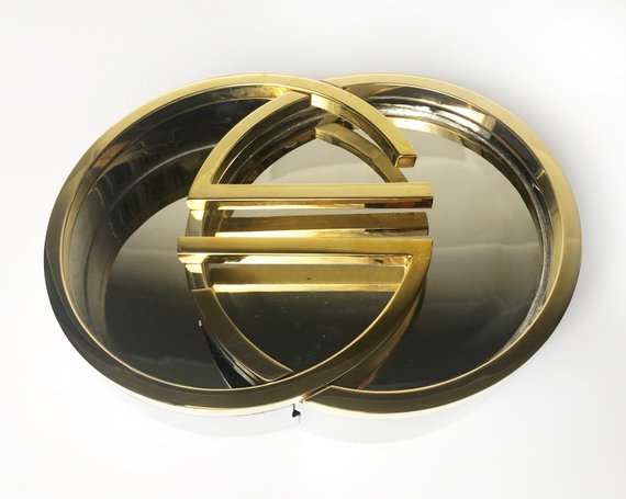 Fruit Vintage rare 1980's Gucci Logo double G ashtray set comprised of two interlocking gold and silver metal G-Shaped trays. This is the most amazing vintage designer home piece!