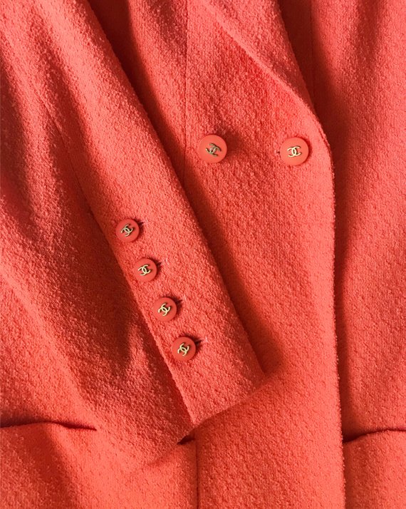 Fruit Vintage Chanel boucle jacket in pale neon peach tone. This jacket is from the famous Spring/Summer 1996 RTW collection by Karl Lagerfeld. It features a longer-line length, classic Chanel logo buttons, internal chain hem and two front pockets.