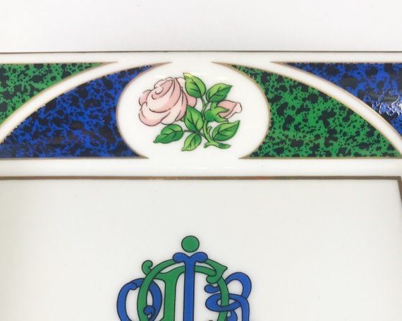 FRUIT Vintage Christian Dior very rare porcelain change tray featuring the 1980s logo in the center surrounded by vibrant green and blue tones and floral motifs.