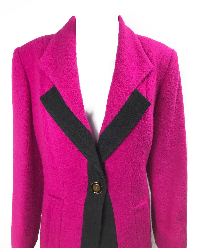 A fabulous bright pink Givenchy jacket dating to the 1980s. This bright piece features a contrast grey trim and large gold buttons.