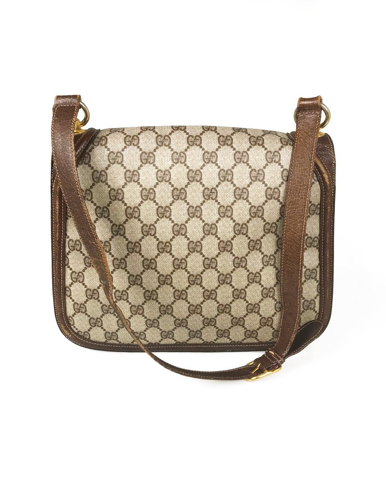 The 1973 Blondie bag is one of the most iconic Gucci styles!  This gorgeous shoulder bag features a very large front double G Gucci Logo at the front, a classic flap closure, brown leather trim and internal zipper pocket.