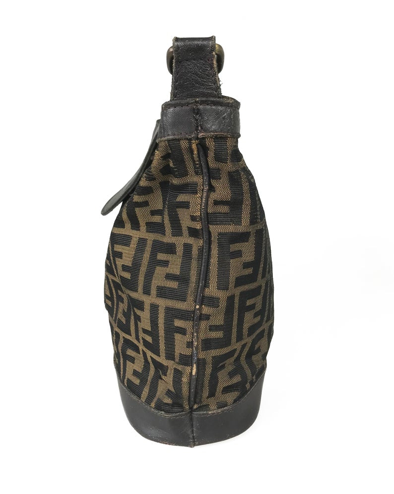 FRUIT Vintage Fendi Zucca cross body bucket bag dating to the 1980s. It features the classic Fendi Zucca monogram canvas, front embossed logo, top push button closure and long adjustable cross body strap..