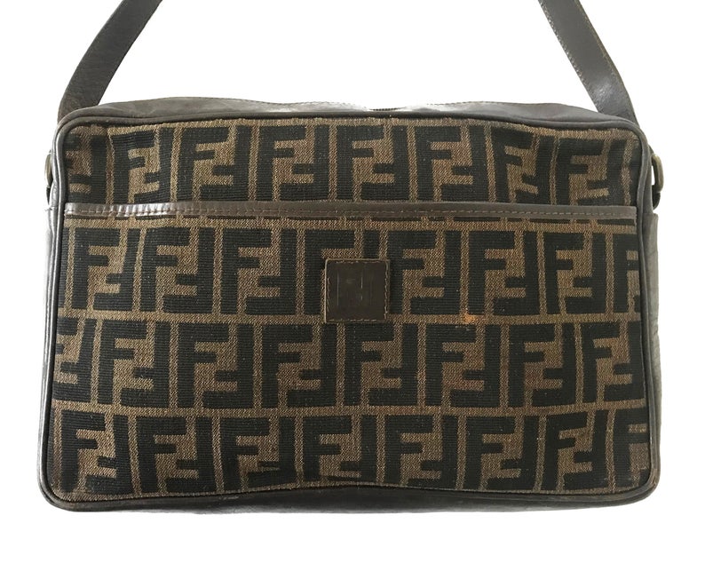 FRUIT Vintage Fendi Zucca cross body satchel handbag dating to the 1980s. It features the classic Fendi Zucca monogram canvas, front embossed logo, top zipper closure and long adjustable cross body strap bag.