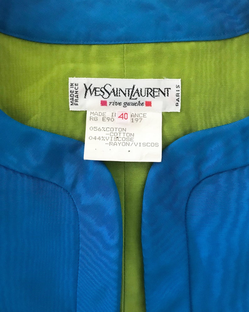 FRUIT Vintage Yves Saint Laurent Rive Gauche turquoise blue crop jacket dating to the 1980s. In near mint condition, this amazing piece features bright green lining and very large blue glass features buttons to each cuff.