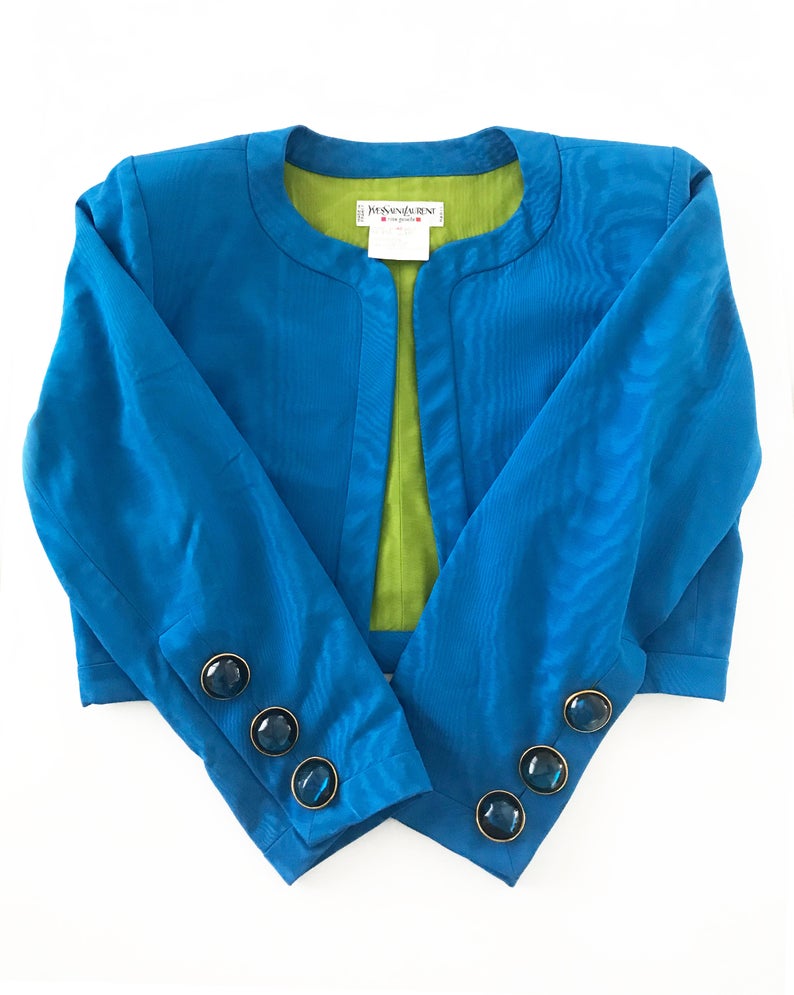 FRUIT Vintage Yves Saint Laurent Rive Gauche turquoise blue crop jacket dating to the 1980s. In near mint condition, this amazing piece features bright green lining and very large blue glass features buttons to each cuff.