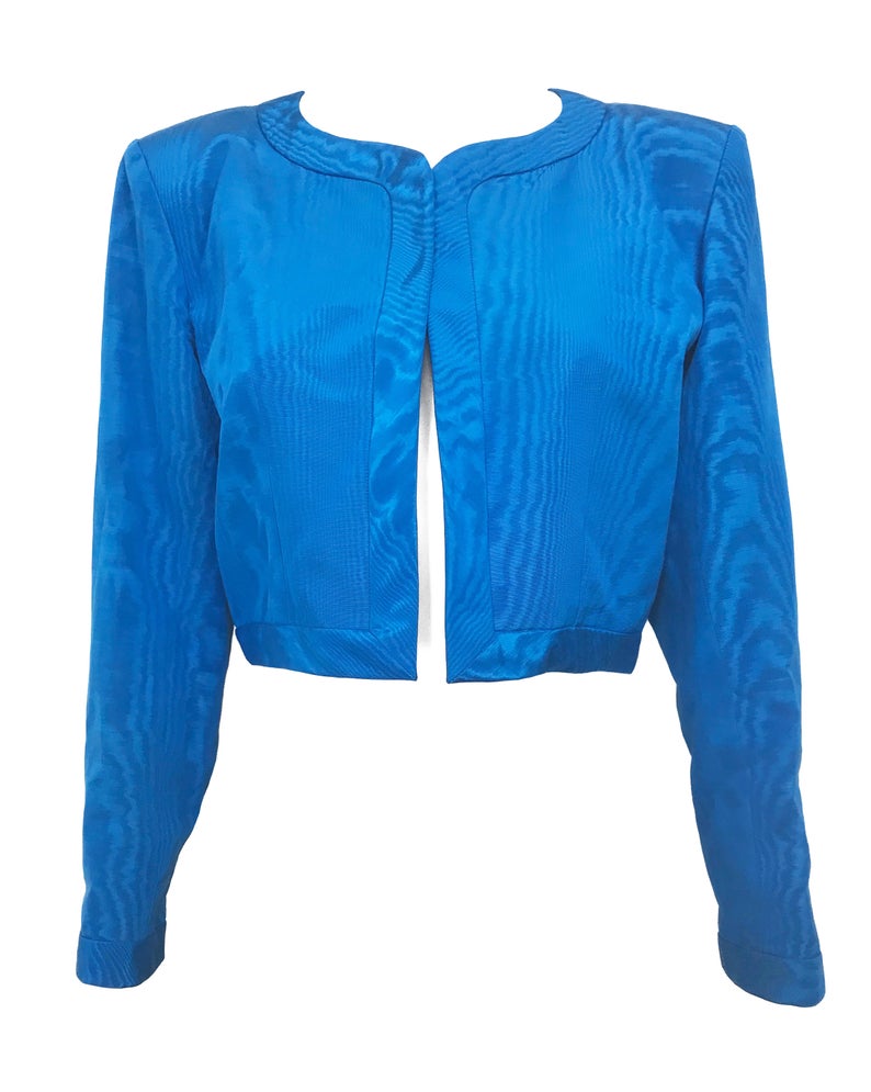 FRUIT Vintage Yves Saint Laurent Rive Gauche turquoise blue crop jacket dating to the 1980s. In near mint condition, this amazing piece features bright green lining and very large blue glass features buttons to each cuff.