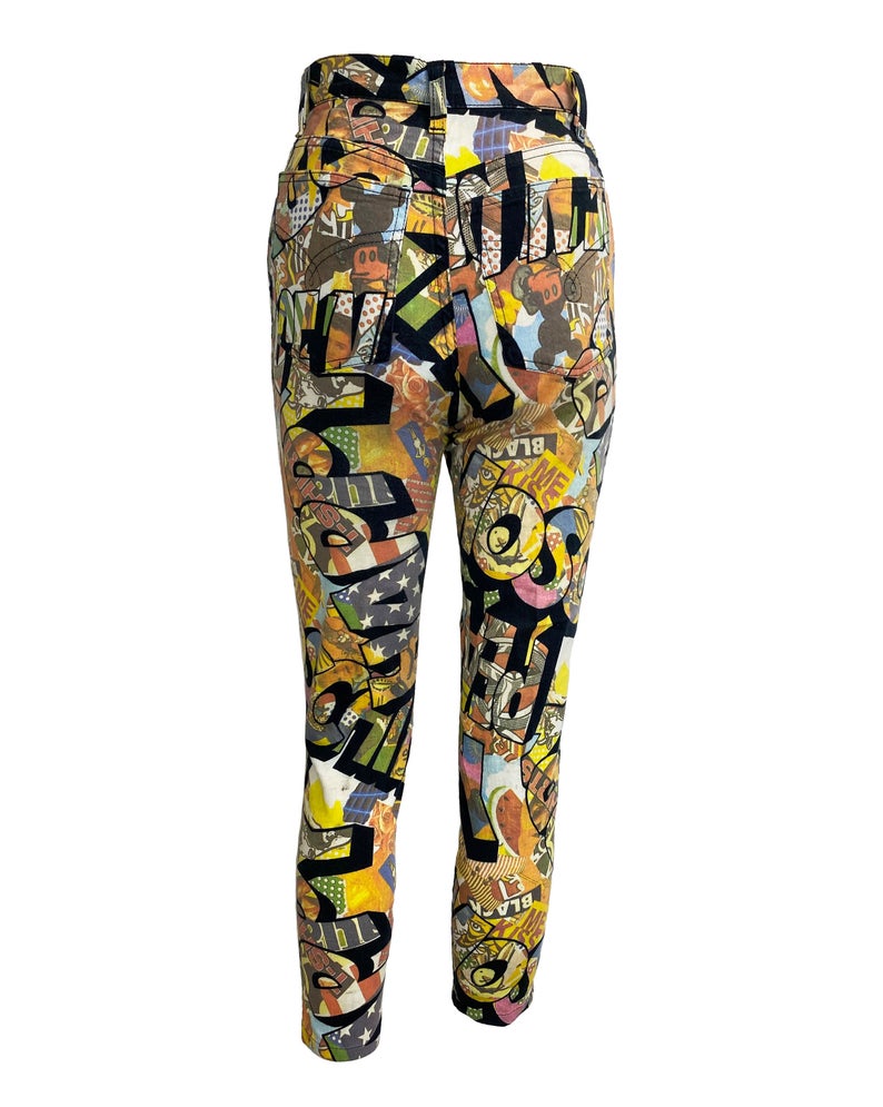 FRUIT Vintage Moschino cartoon print jeans dating to the early 1990s. They feature a classic mid-waist cut with a soft stretch denim and the incredible custom 90s Moschino logo print all over