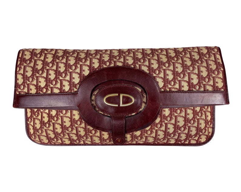 FRUIT vintage 1970s Christian Dior convertible monogram clutch/tote bag as worn by Carrie in Sex and City, it features a Christian Dior 1970s logo at front with snap closure for when it is folded to become a clutch, classic oblique trotter canvas and leather handles.