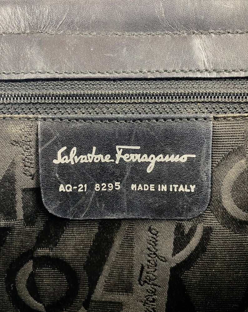 FRUIT Vintage 1980s Salvatore Ferragamo bag in black leather. This is such an elegant bag, in an iconic Ferragamo shape. Features a classic Ferragamo logo buckle closure, internal zipper pocket with logo pull and logo lining.