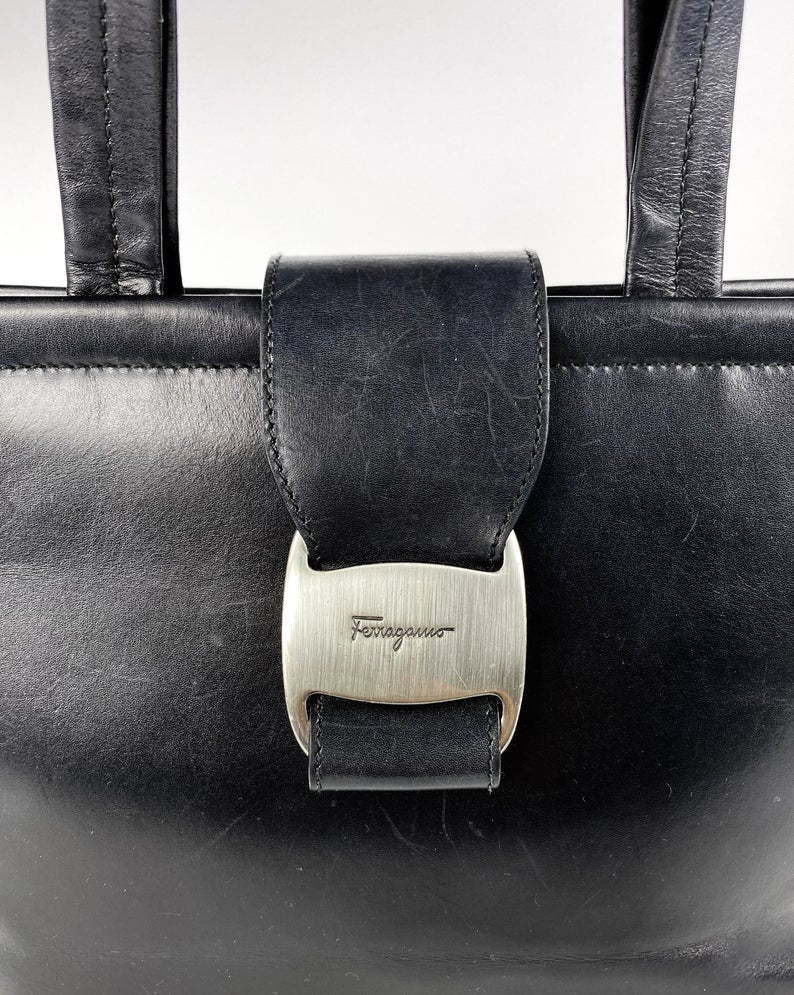 FRUIT Vintage 1980s Salvatore Ferragamo bag in black leather. This is such an elegant bag, in an iconic Ferragamo shape. Features a classic Ferragamo logo buckle closure, internal zipper pocket with logo pull and logo lining.