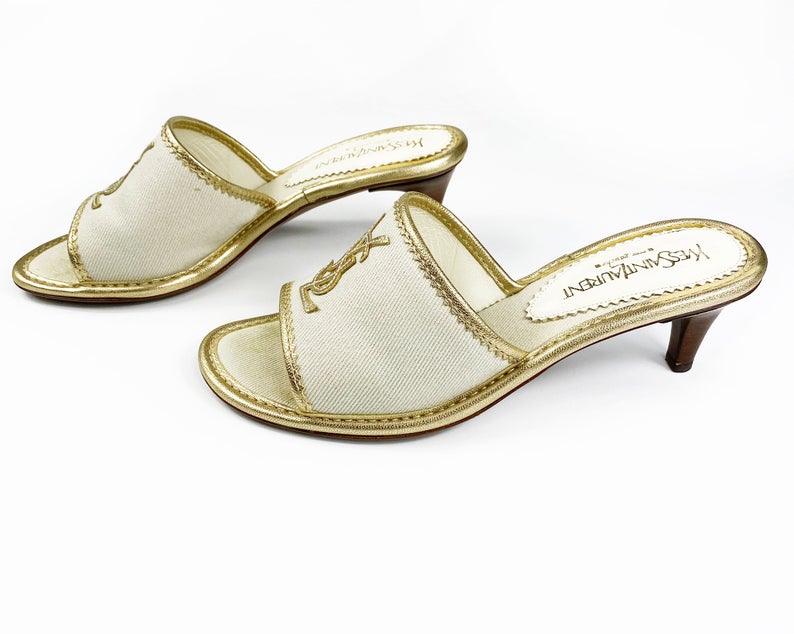 FRUIT Vintage Yves Saint Laurent logo canvas mules with gold leather trim. Features a a large gold leather YSL logo at front and stacked wooden heels.