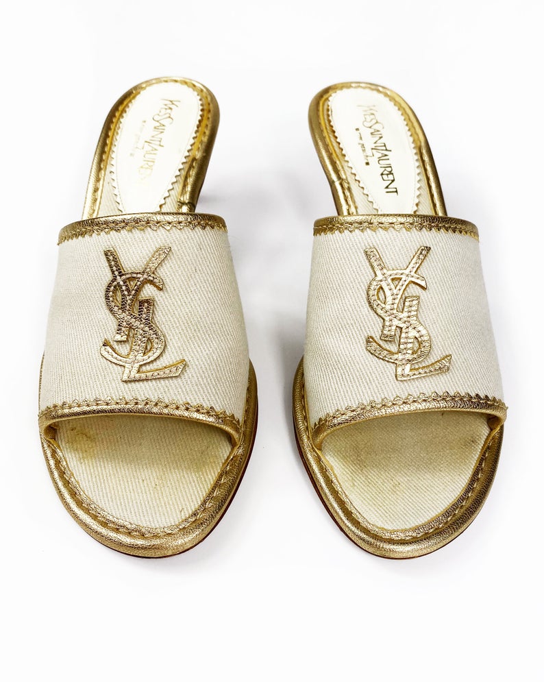 FRUIT Vintage Yves Saint Laurent logo canvas mules with gold leather trim. Features a a large gold leather YSL logo at front and stacked wooden heels.