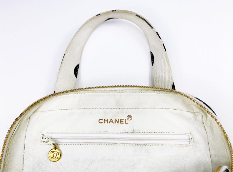 Fruit Vintage Chanel 1997 white/ black quilted logo canvas mini zipper tote makeup vanity bag. It includes 2 external pouch pockets, a logo ball zipper pull, full leather lining, and internal zipper pocket with Chanel logo pull. As seen on Ariana Grande.