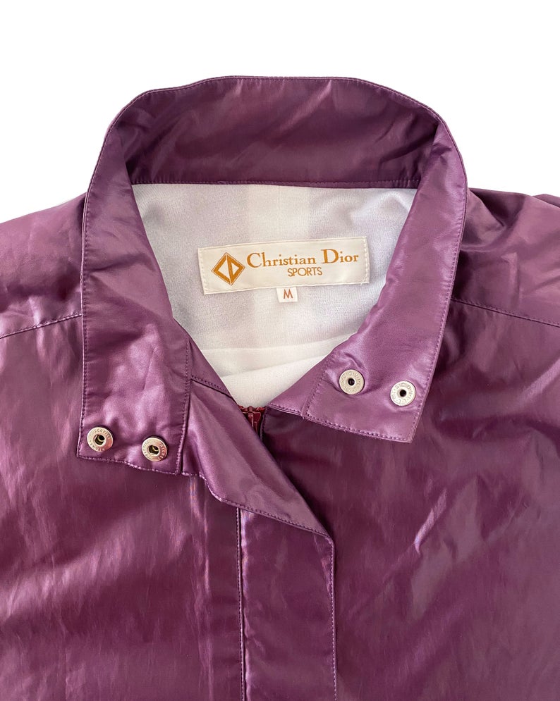 FRUIT Vintage rare Purple Christian Dior Sport Logo bomber jacket from the 1980s. It features a classic 1980s bomber jacket cut with over flap and large Christian Dior Sport text logo printed at rear.